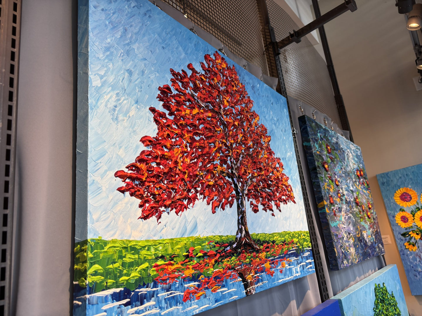Colorful mosaic artwork of a red tree with a blue sky background by Isabelle Dupuy