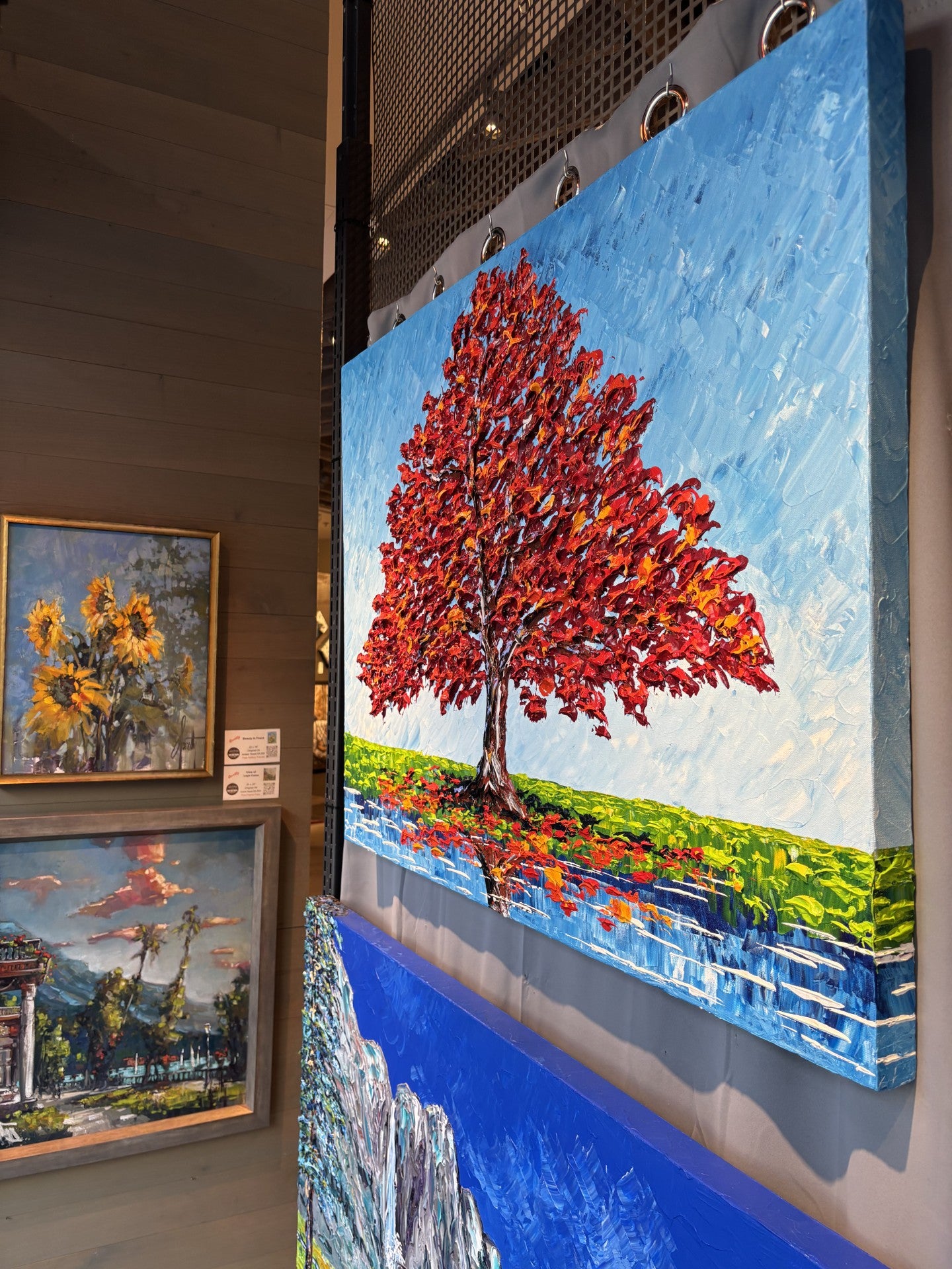 Painting of a red tree on a blue sky background in at Gallery 1870 in Downtown Napa - by Isabelle Dupuy