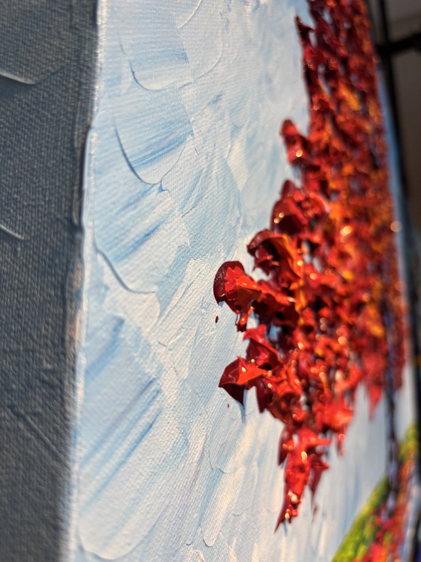 Close-up of a painting with red elements and textured blue background at Gallery 1870 in downtown Napa