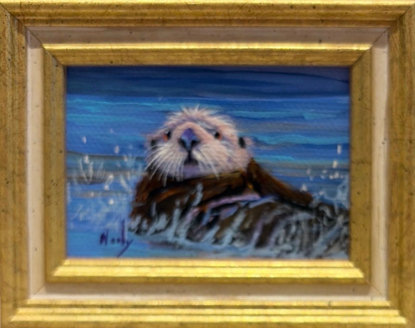 Otter original acrylic painting by Karen Neely featuring a playful sea otter floating in blue ocean water, custom framed in an Italian gold moulding.