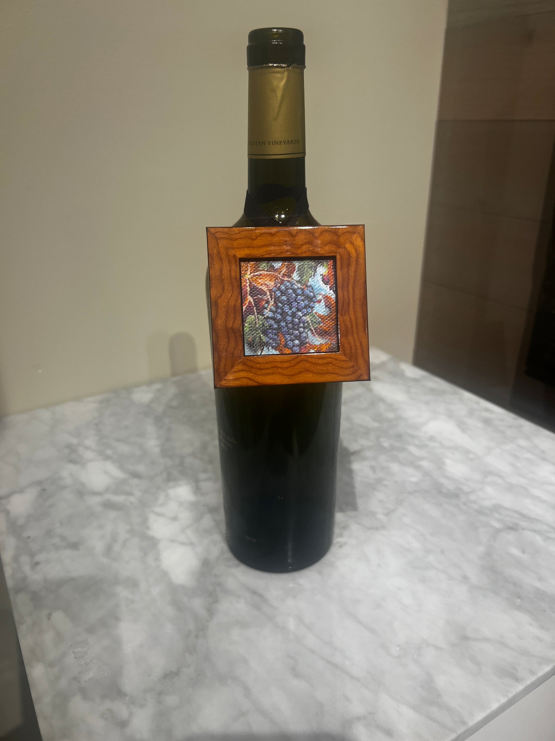 Miniature grapes painting by Karen Neely in burl wood frame hanging on wine bottle