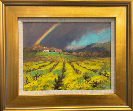 Rainbow Over Vineyards original oil painting by Tania Yukhimets featuring Napa Valley vineyard rows, rainbow, hillside home, and dramatic storm sky, framed in gold.